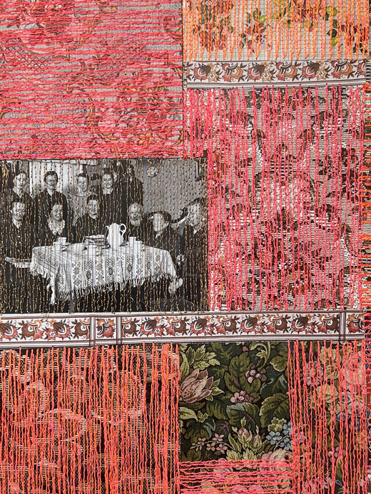 [Translate to Englisch:] Ein Patchwork aus floralen und gemusterten Stoffquadraten, hauptsächlich in Rosa- und Orangetönen, mit vertikal herabhängenden orangefarbenen Fäden. Ein Quadrat enthält ein Schwarzweißfoto von Personen, die an einem Tisch sitzen.